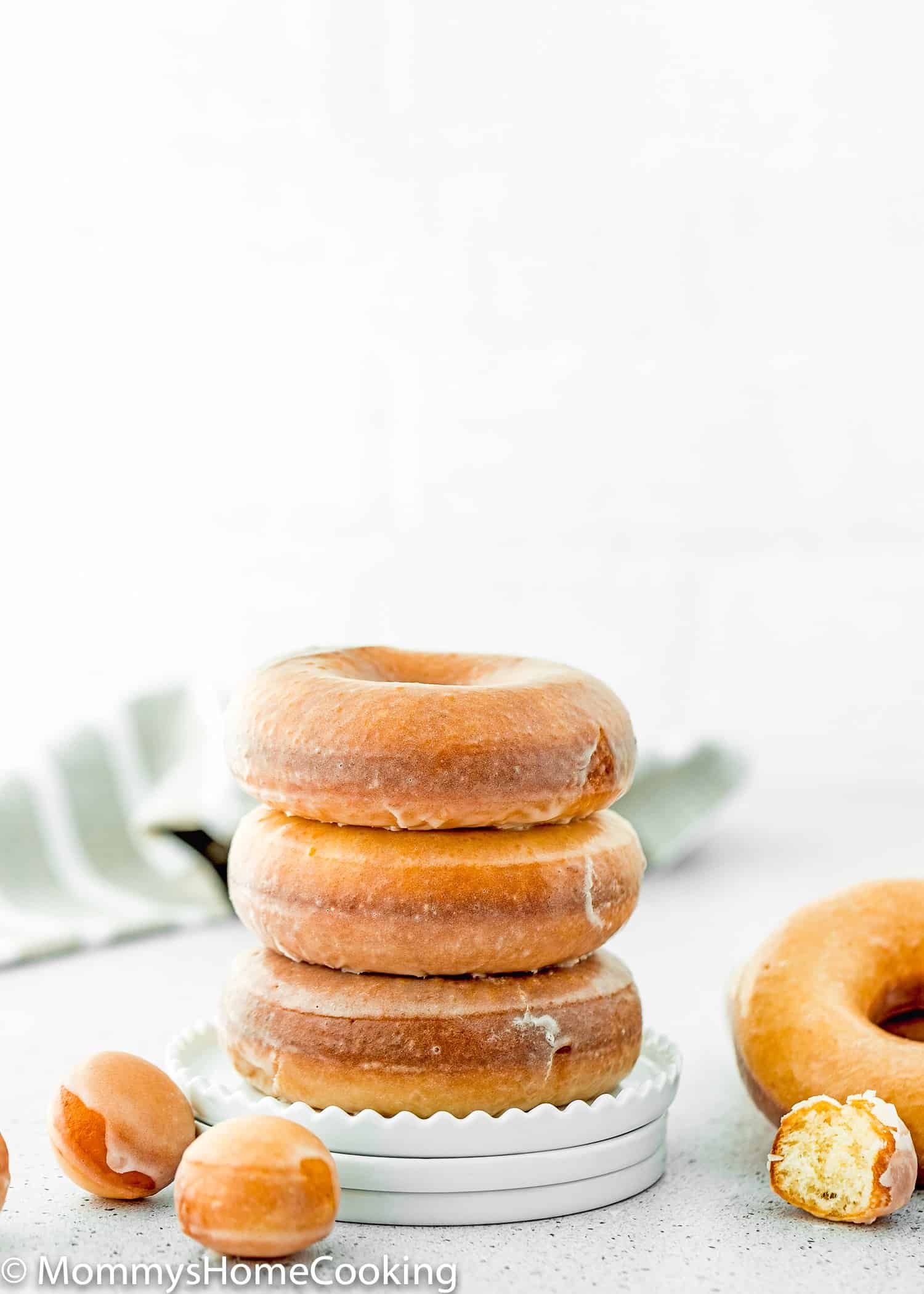 a stack of eggless glazed donuts in a plate.