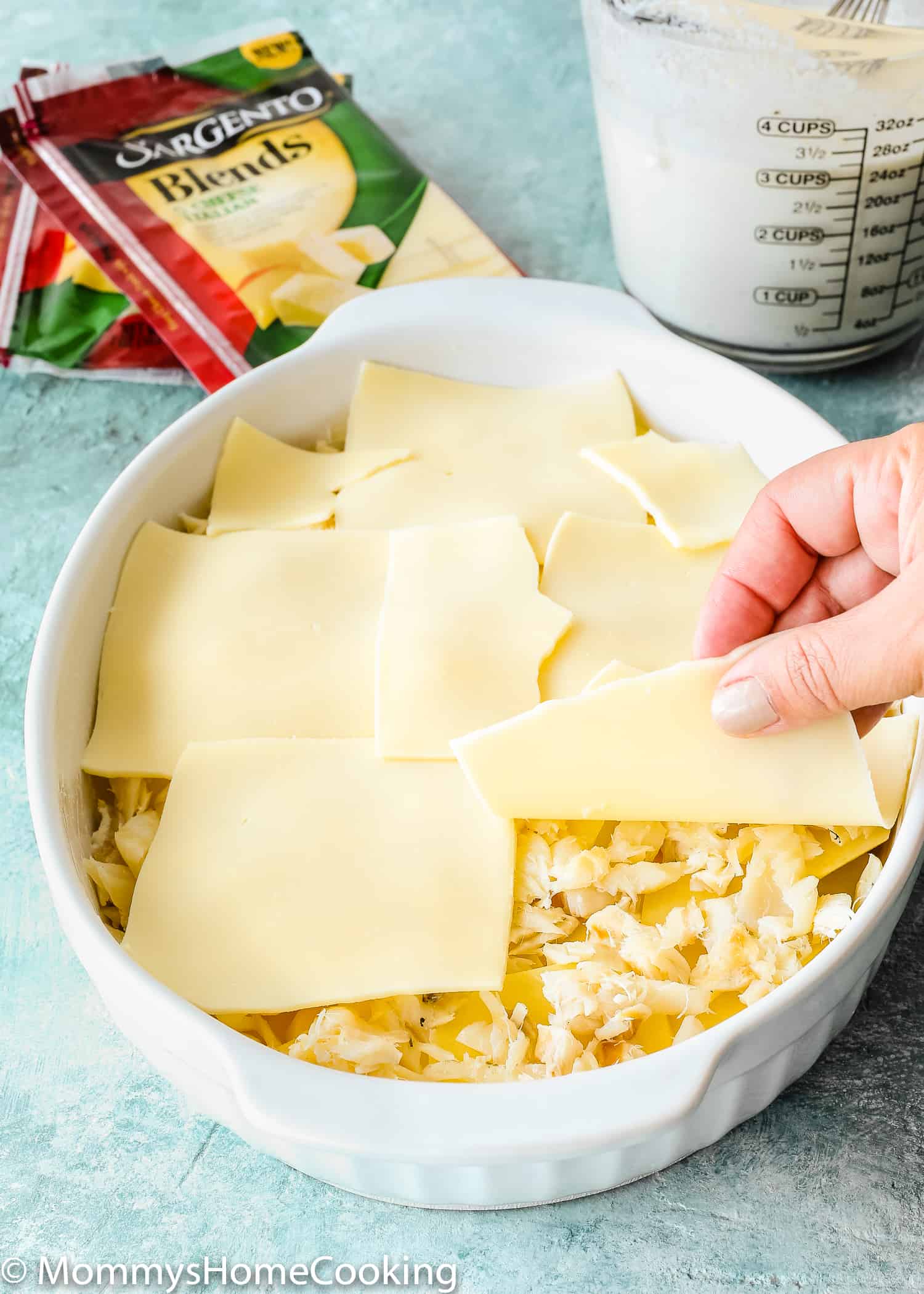 This Cheesy Potatoes and Cod Casserole recipe is cheesy, creamy, and easy to make! Loaded Potato, cheese and cod, this dish is a whole dinner in one! For sure a go-to dinner for any day of the week. https://mommyshomecooking.com