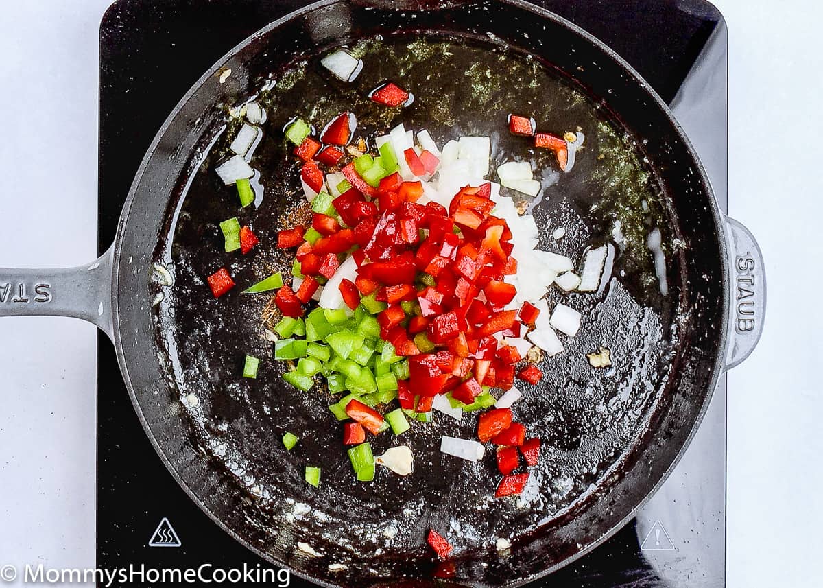 chopped onion and green and red peppers in a skillet.