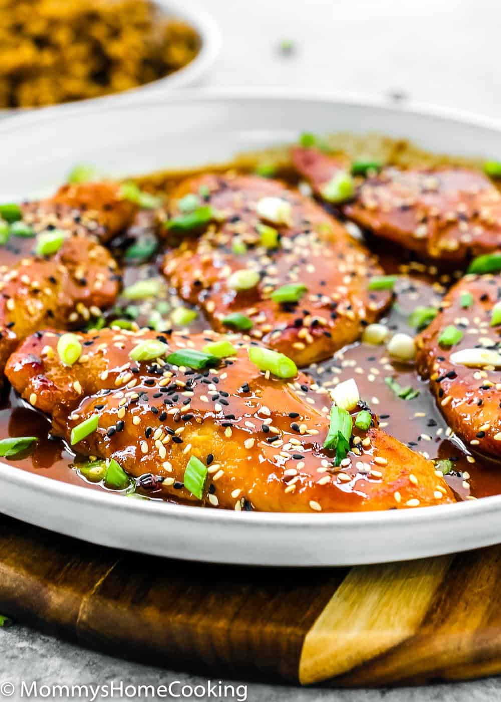 Easy Asian-Style Chicken Breasts in a white skillet  with tasty sauce