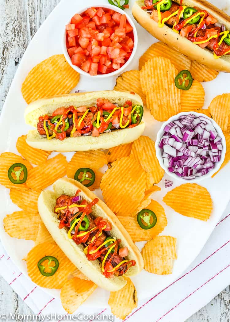 These Easy Bacon-Wrapped Hot Dogs are perfect for a summer weeknight dinner!! Topped with tomato, onion, and jalapeno, this hot dog is a deliciously easy way to say bye-bye to the Ol’ boring bun. https://mommyshomecooking.com