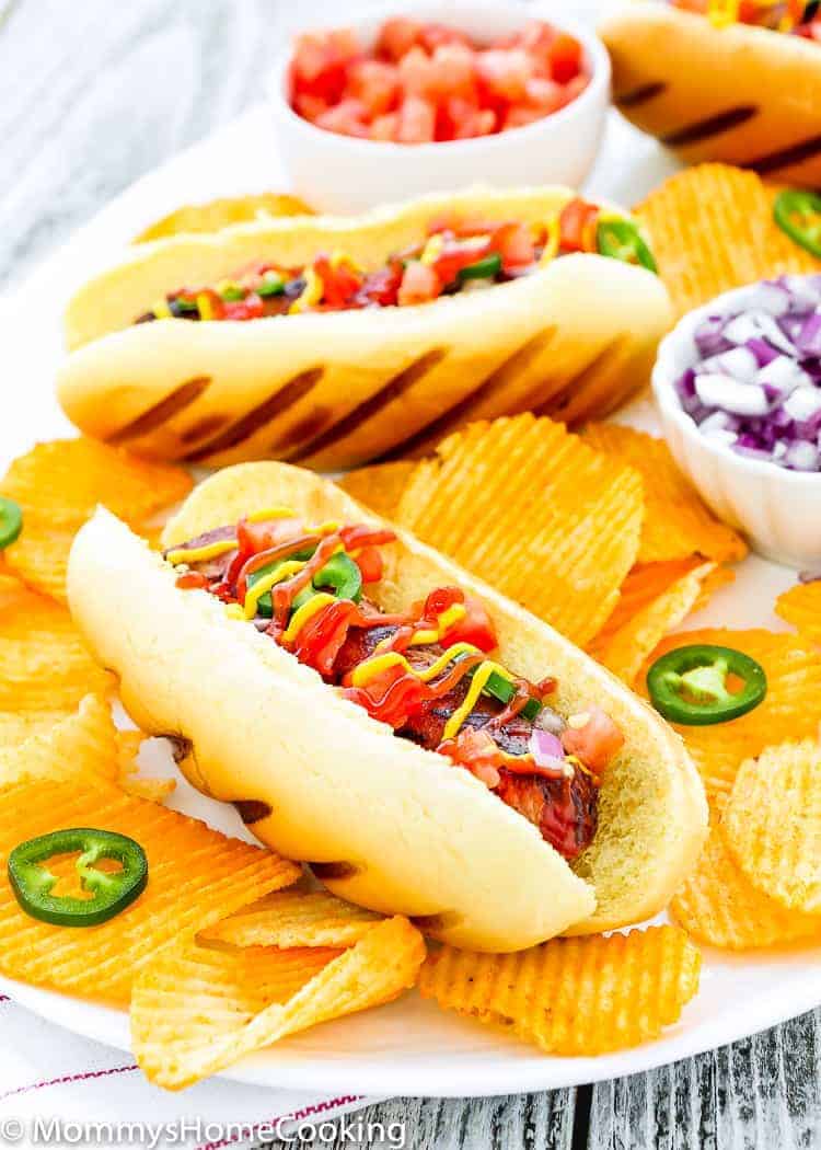 These Easy Bacon-Wrapped Hot Dogs are perfect for a summer weeknight dinner!! Topped with tomato, onion, and jalapeno, this hot dog is a deliciously easy way to say bye-bye to the Ol’ boring bun. https://mommyshomecooking.com