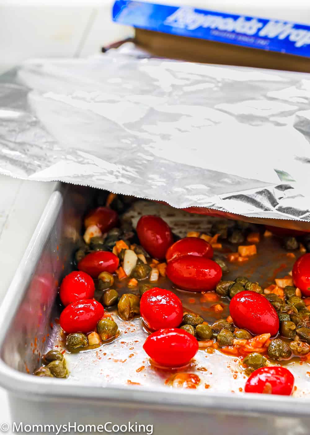 Easy roasted tomatoes and cappers in a baking pan cover with foil