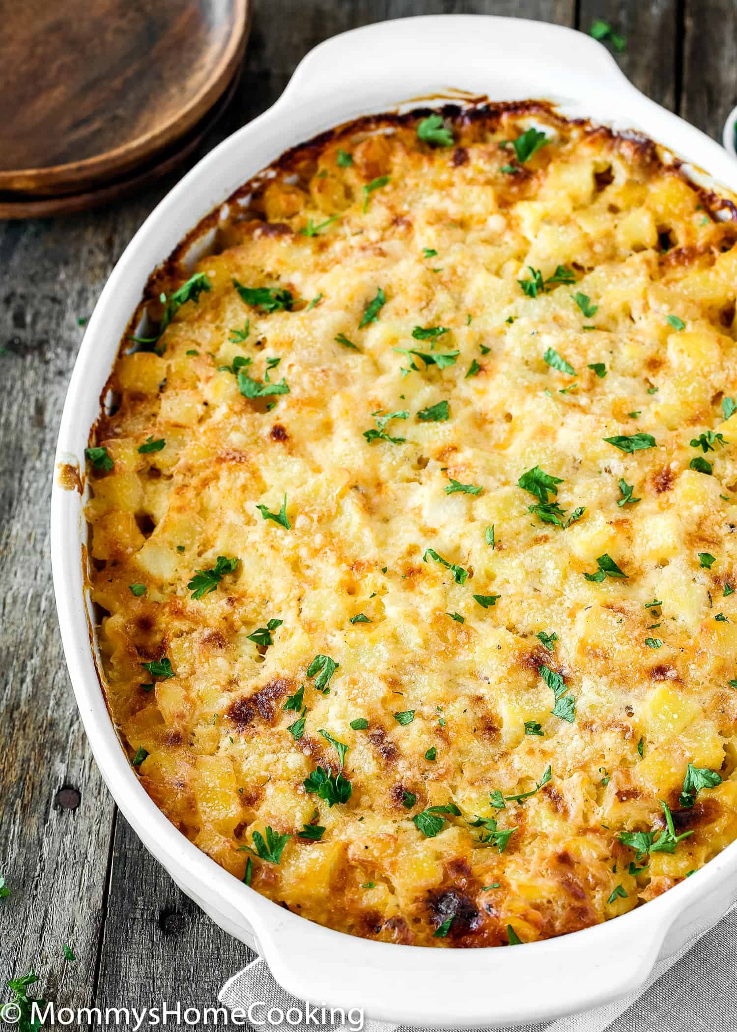 Cheesy Hash Browns Casserole garnished with chopped parsley.