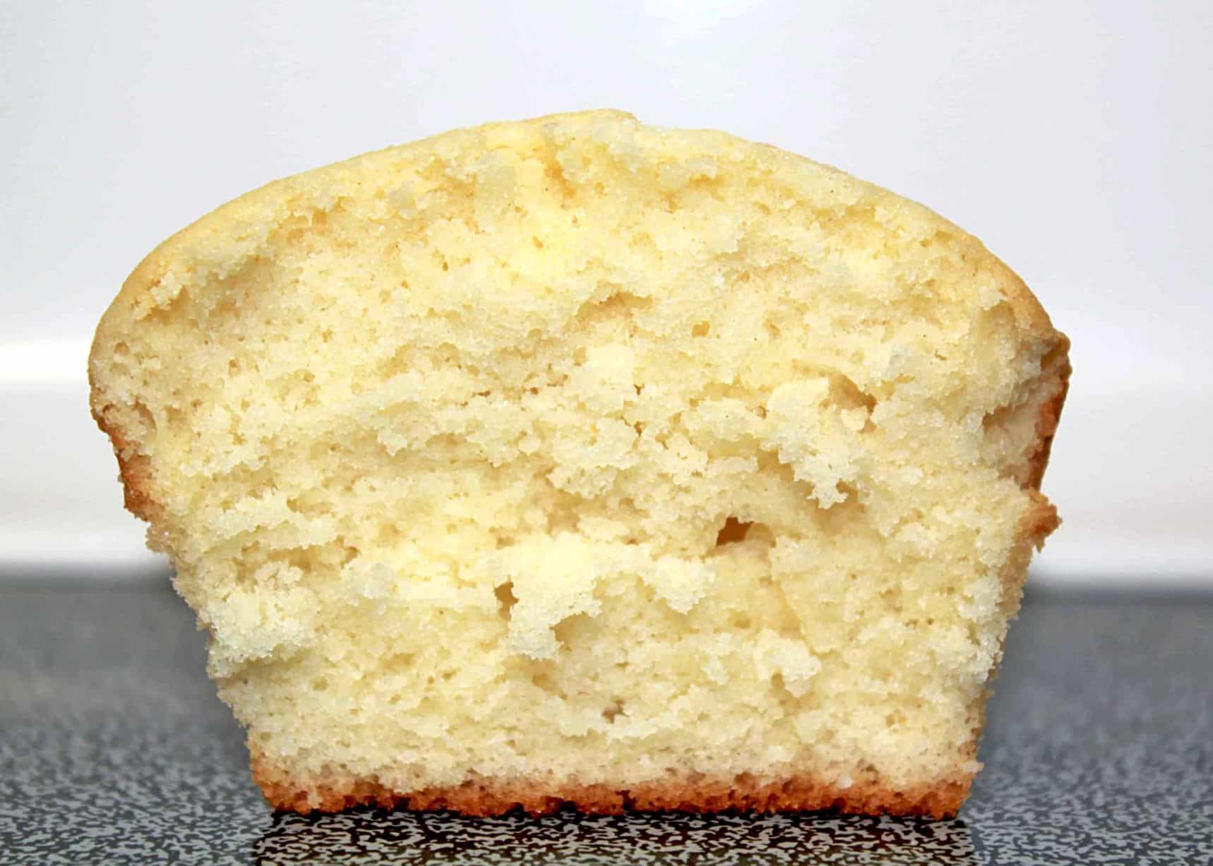 vanilla cupcake cut in half showing its fluffy texture