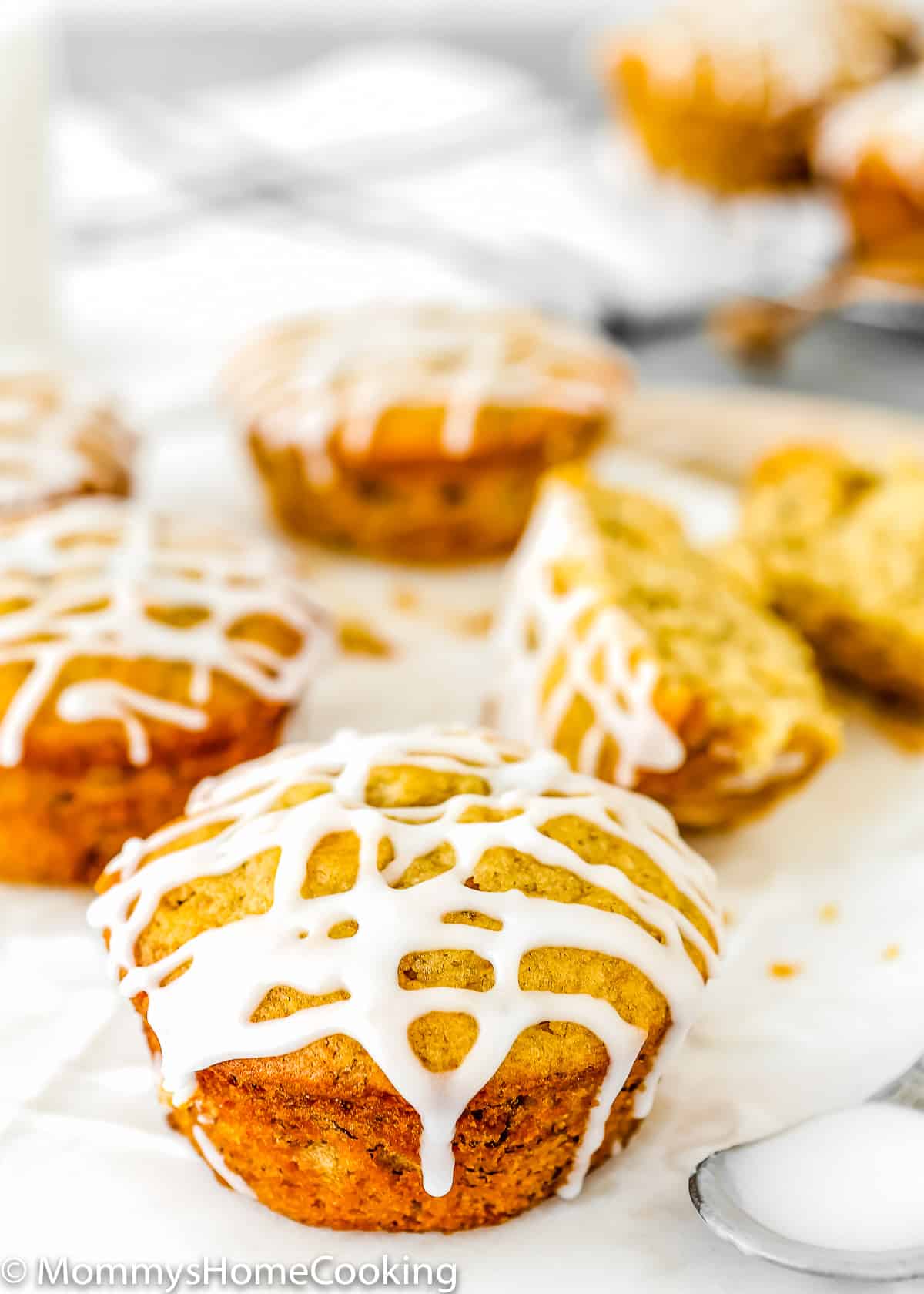 Eggless Banana Bread Muffins with glaze over a marble cutting table with a spoon on the size
