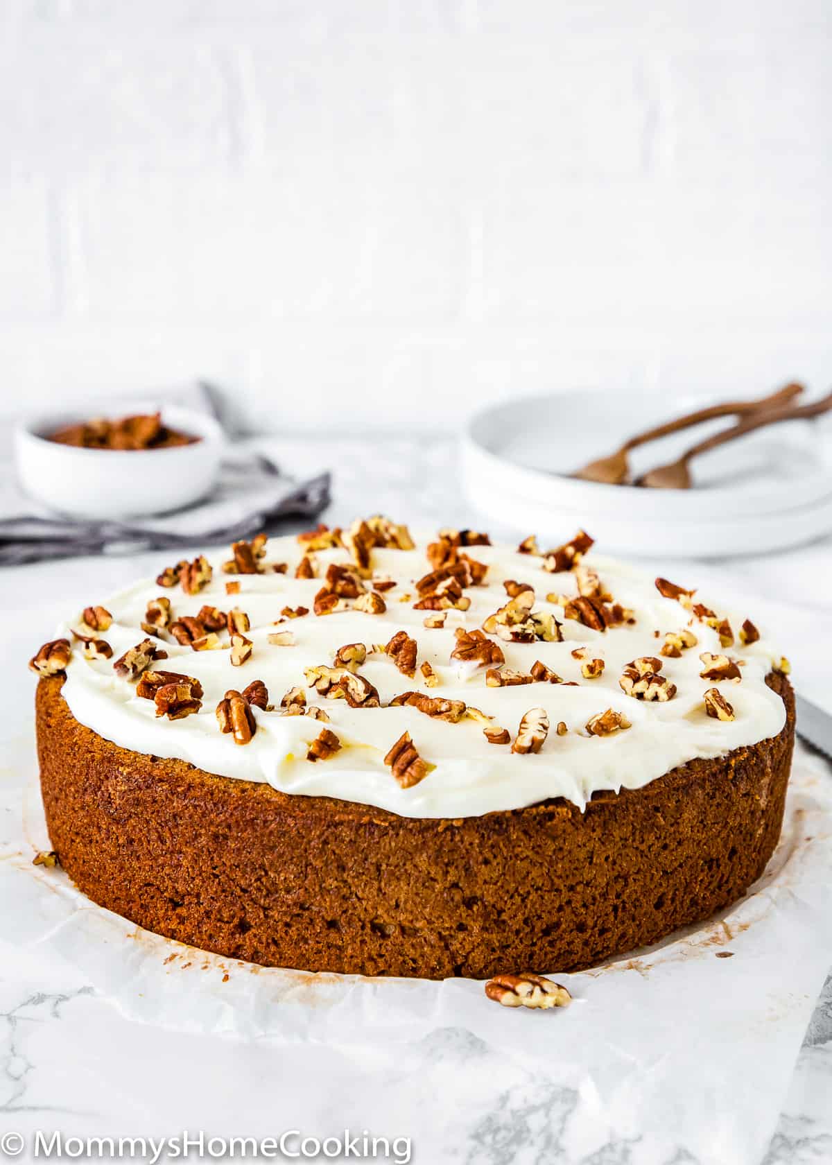  Eggless Banana Cake with frosting over a marble surface.