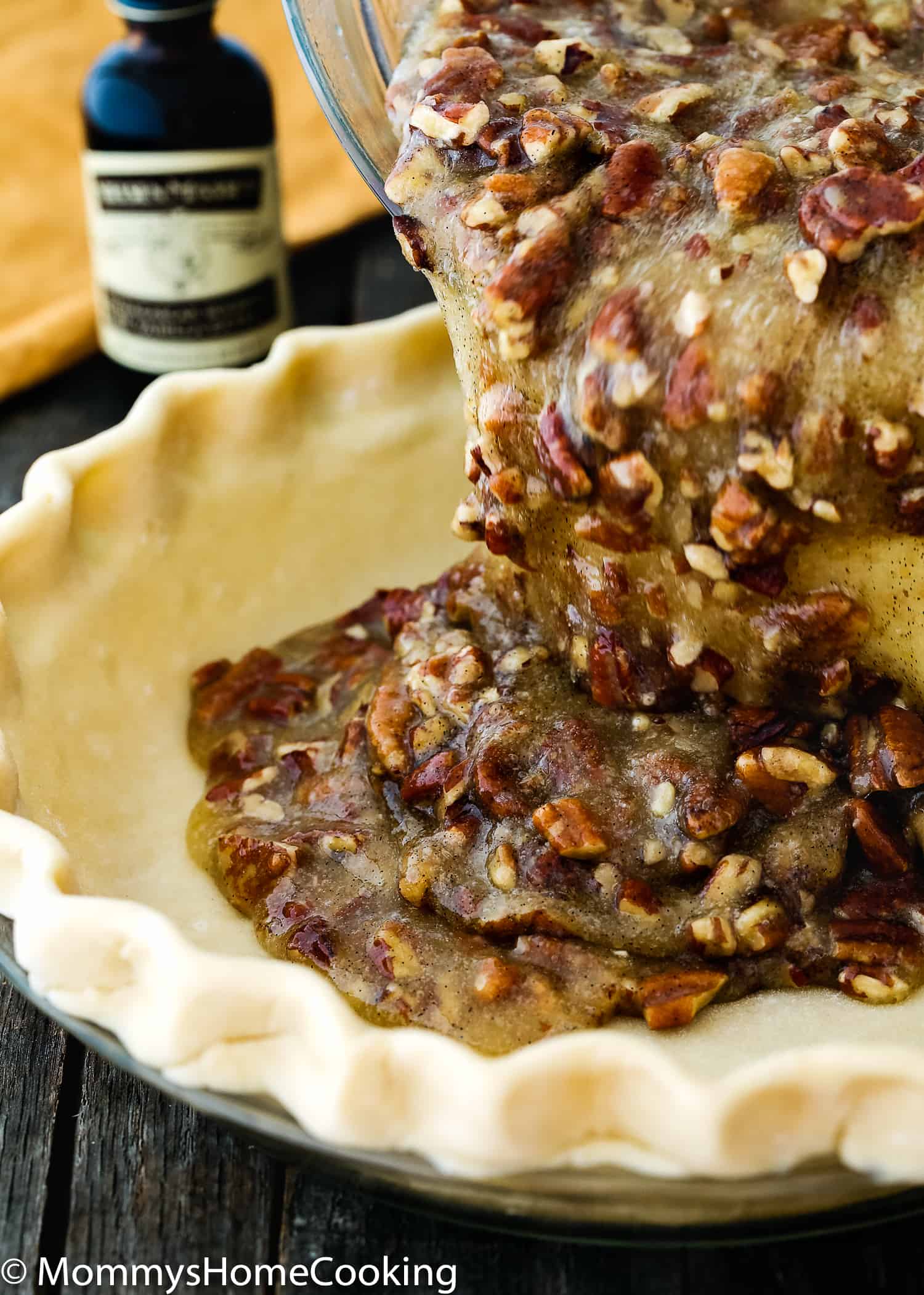 Easy Eggless Pecan Pie filling being poured over a pie crust.