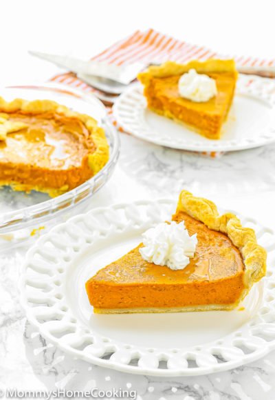 two Eggless Pumpkin Pie slices on white plates over a marble surface