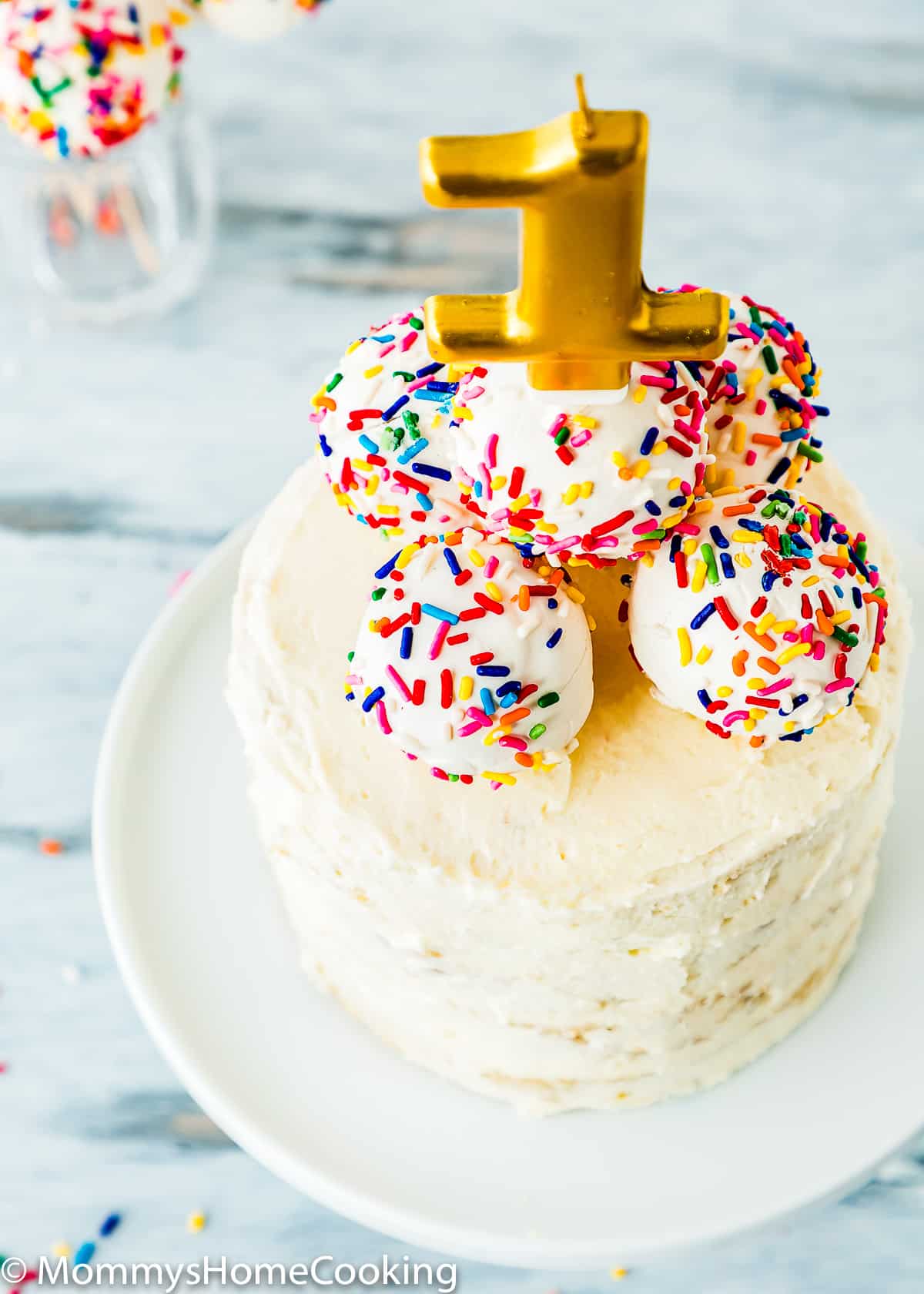 healthy smash cake with cake pops on top and a candle