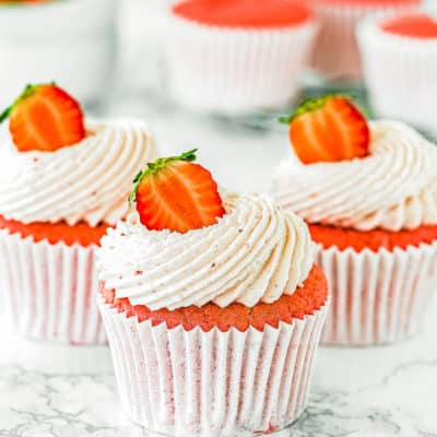 eggless Strawberry cupcakes with strawberry buttercream and fresh Strawberry on top over a marble surface.