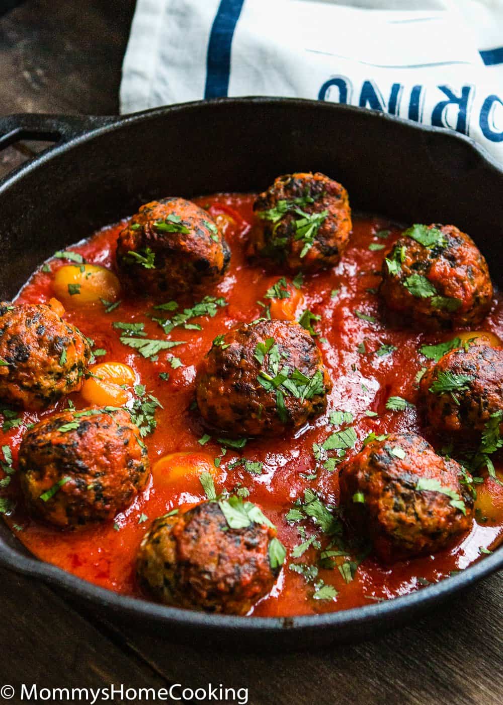 Eggless turkey meat balls with tomato sauce in a cast iron skillet.