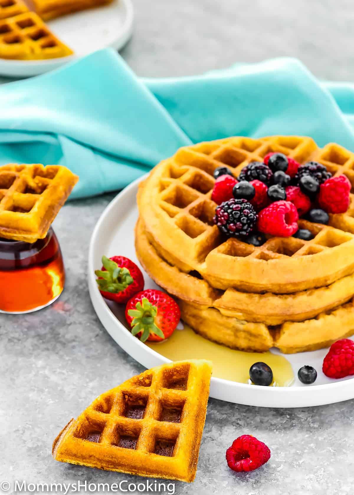 eggless waffles stack with fresh fruit on a gray surface.
