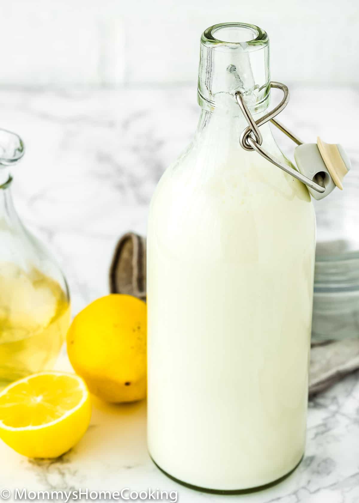 homemade buttermilk in a bottle with lemons in the background.
