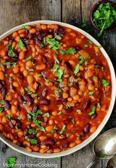 Instant Pot Baked Beans in a bowl with a serving spoon on the side.
