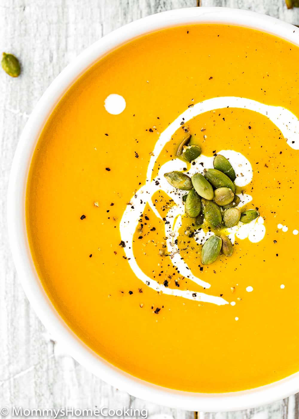 Instant Pot Pumpkin Soup in a bowl with cream and pumpkin seeds