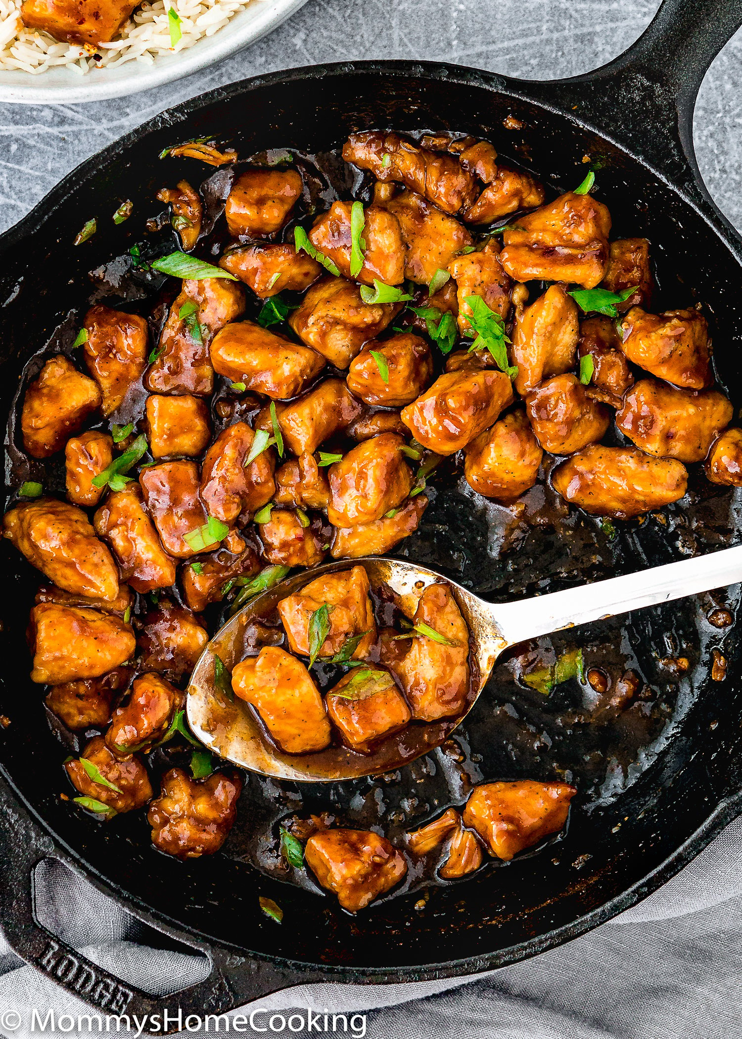 Easy Sticky Bourbon Chicken in a skillet with a serving spoon