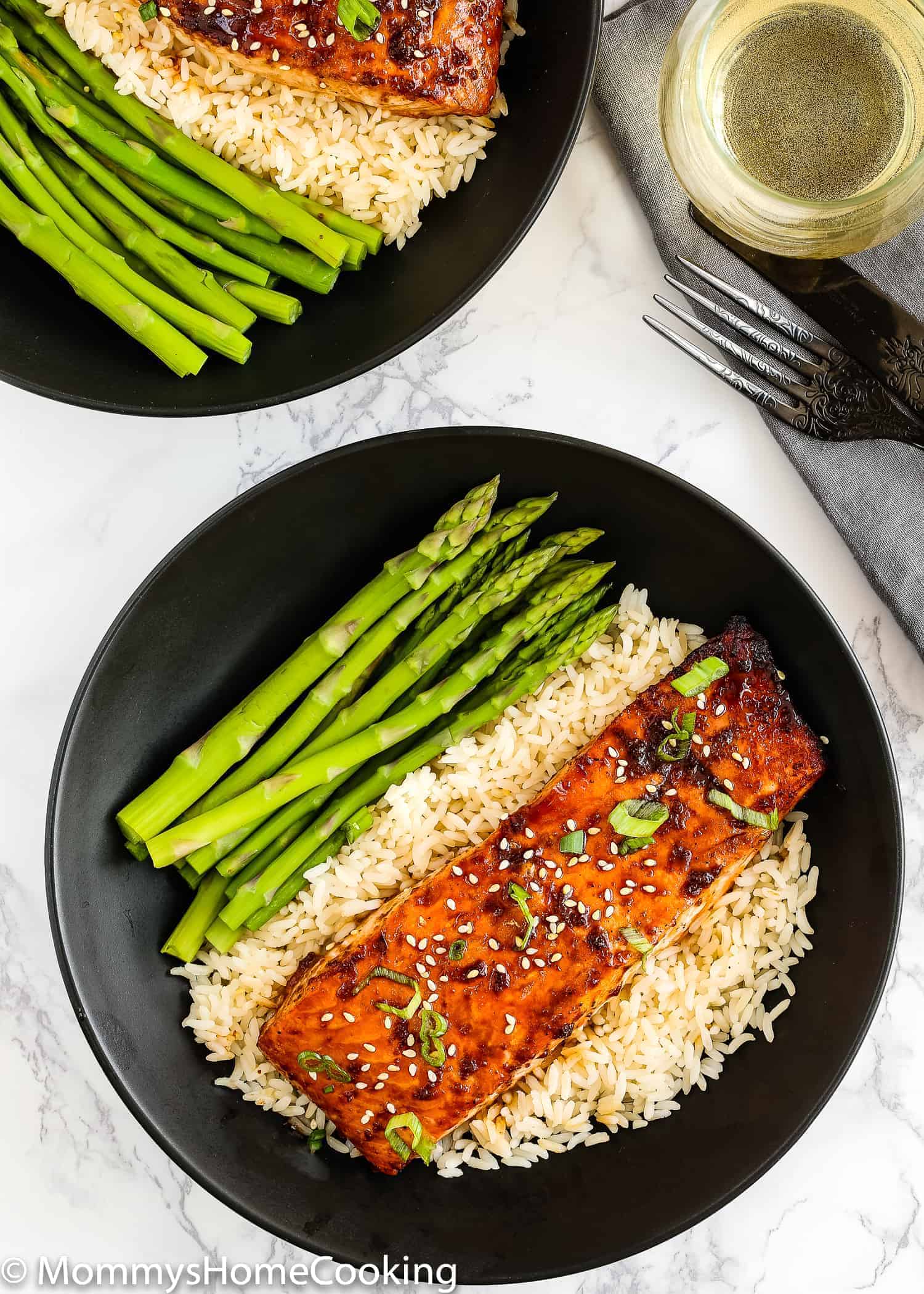 Teriyaki Salmon in a black plate with rice and asparagus 