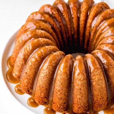 Eggless Apple Cider Donut Cake with brown sugar glaze over a white plate