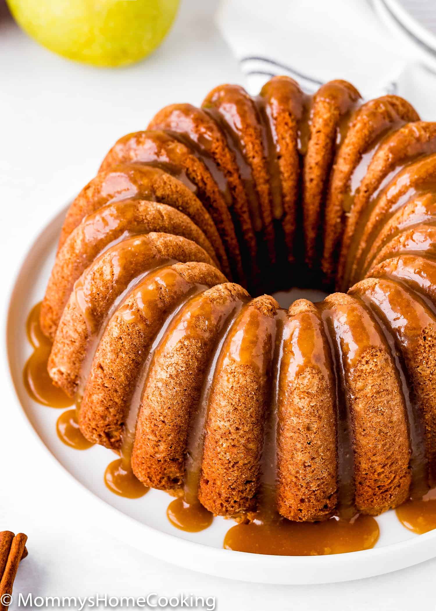 Eggless Apple Cider Donut Cake with brown sugar glaze over a white plate.
