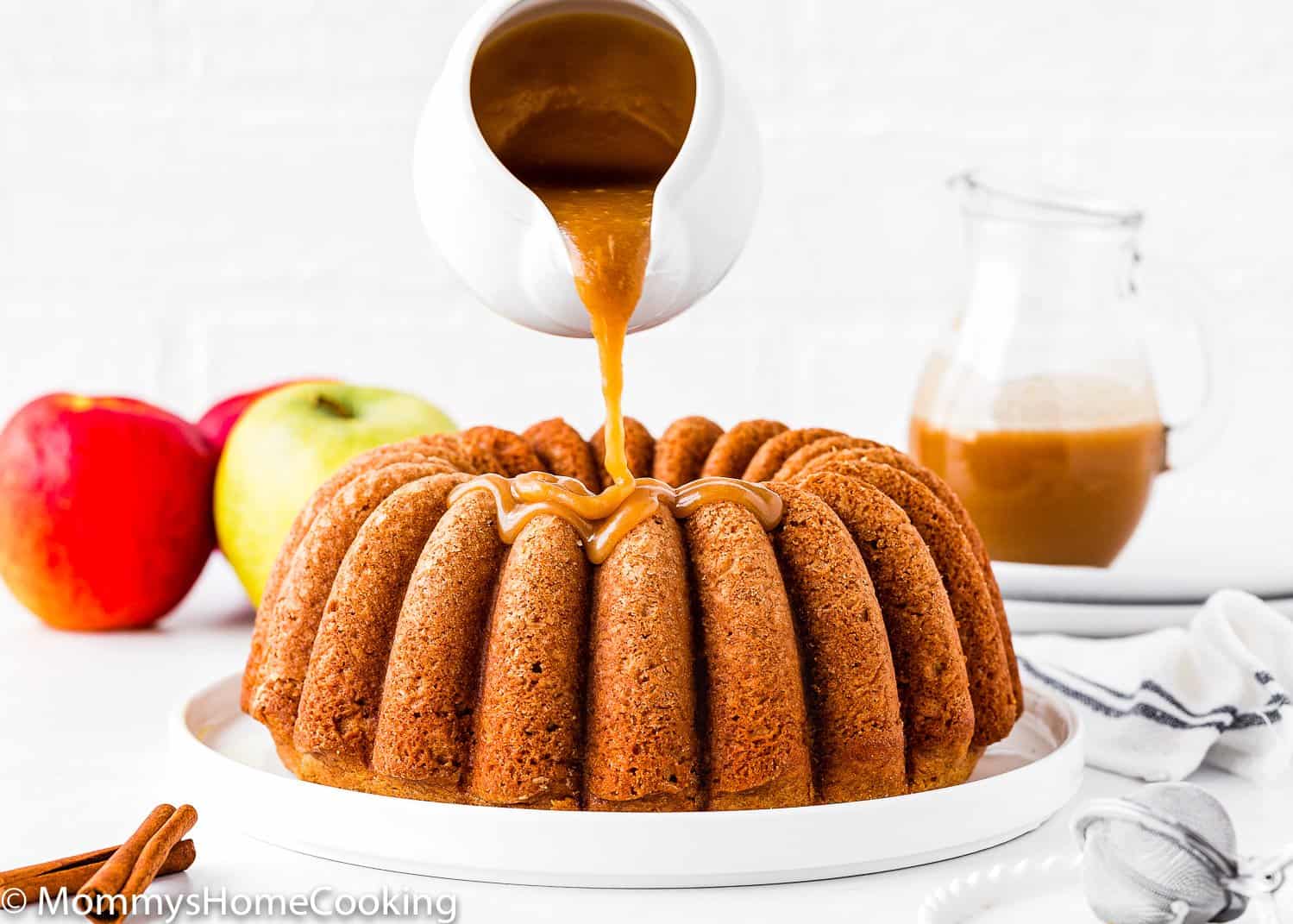Eggless Apple Cider Donut Cake being drizzled with brown sugar glaze.