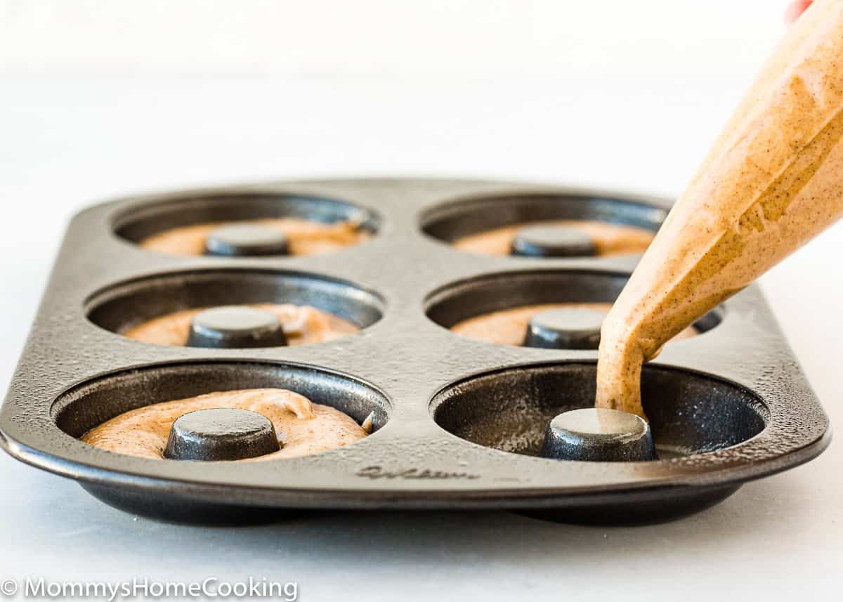 piping bag filling a donut pan