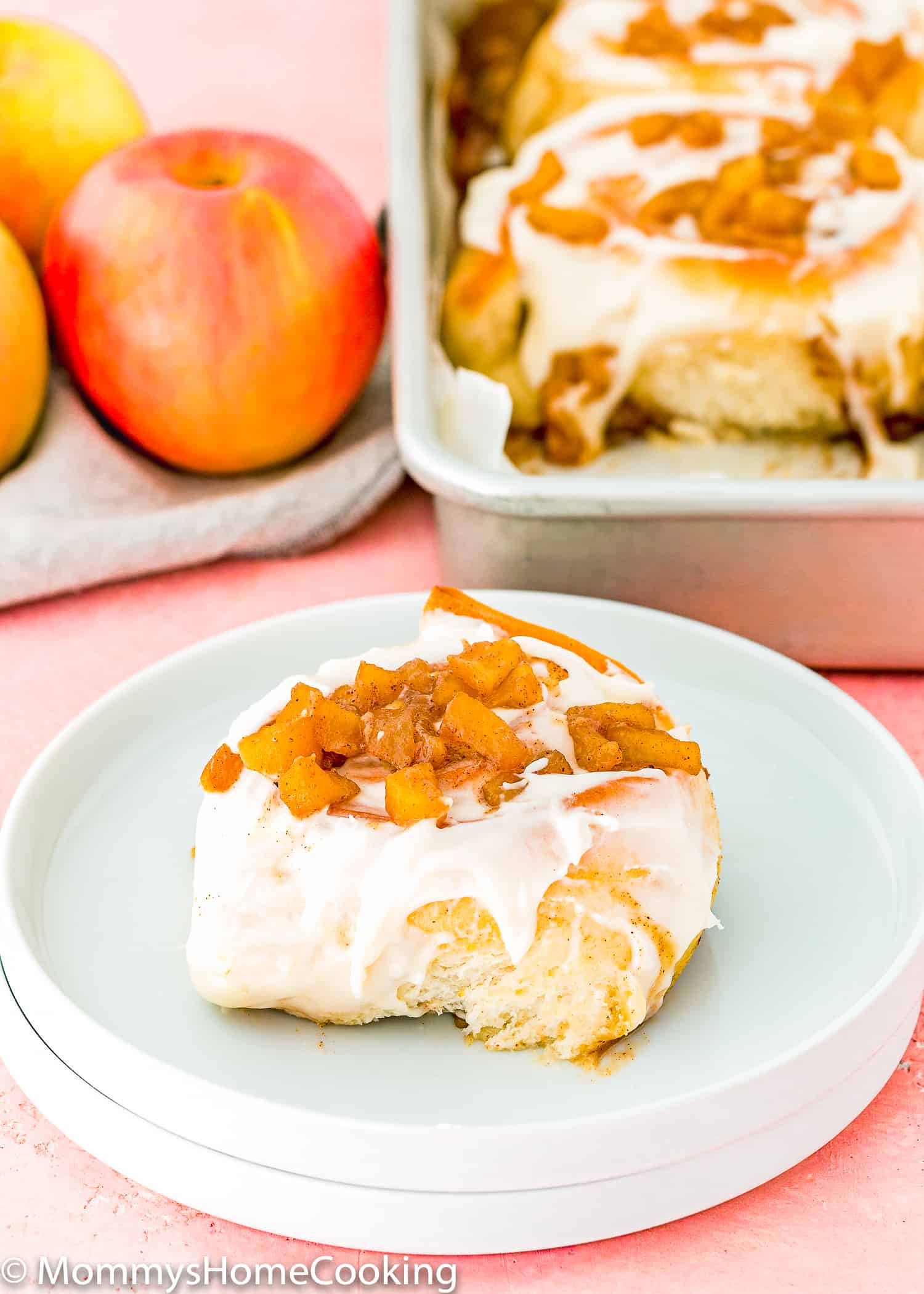 Eggless Apple Cinnamon Roll with icing on a plate. 