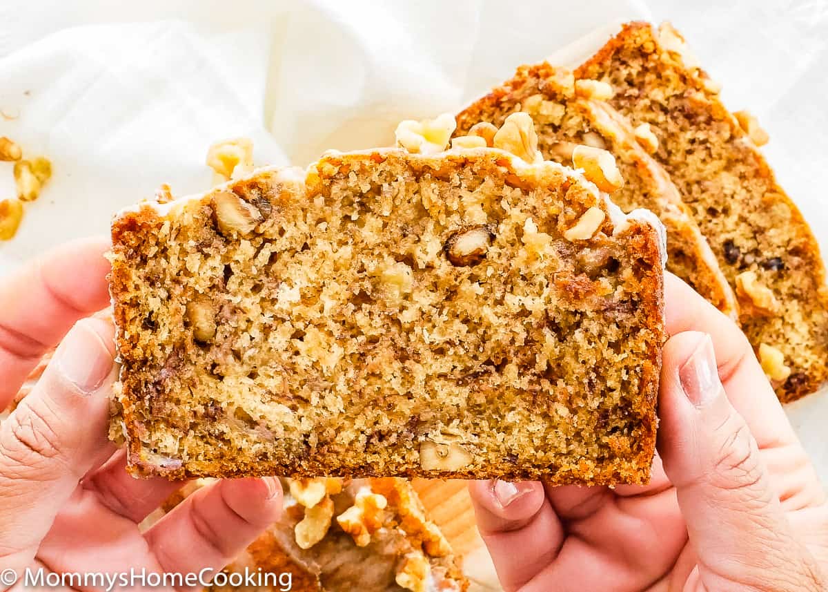 hands holding a slice of eggless banana bread
