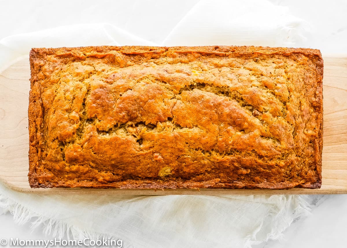 a whole eggless banana bread over a wooden cutting board