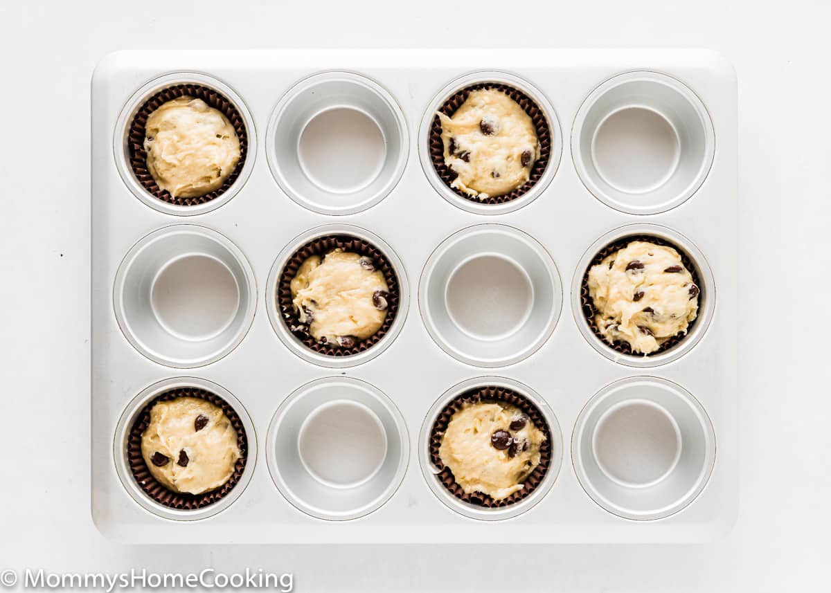 muffin pan with paper liner and Eggless Banana Chocolate Chip Muffin batter.