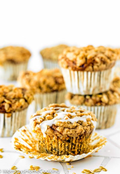 eggless banana crumb muffins with glaze over a white surface