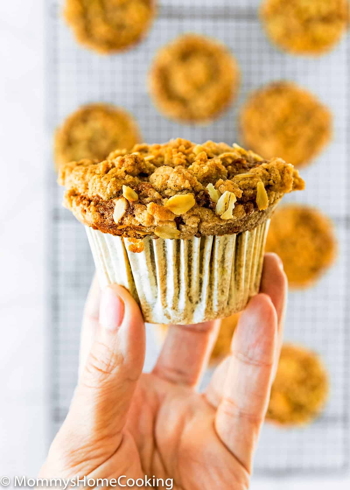 a hand holding an eggless crumb banana muffin.