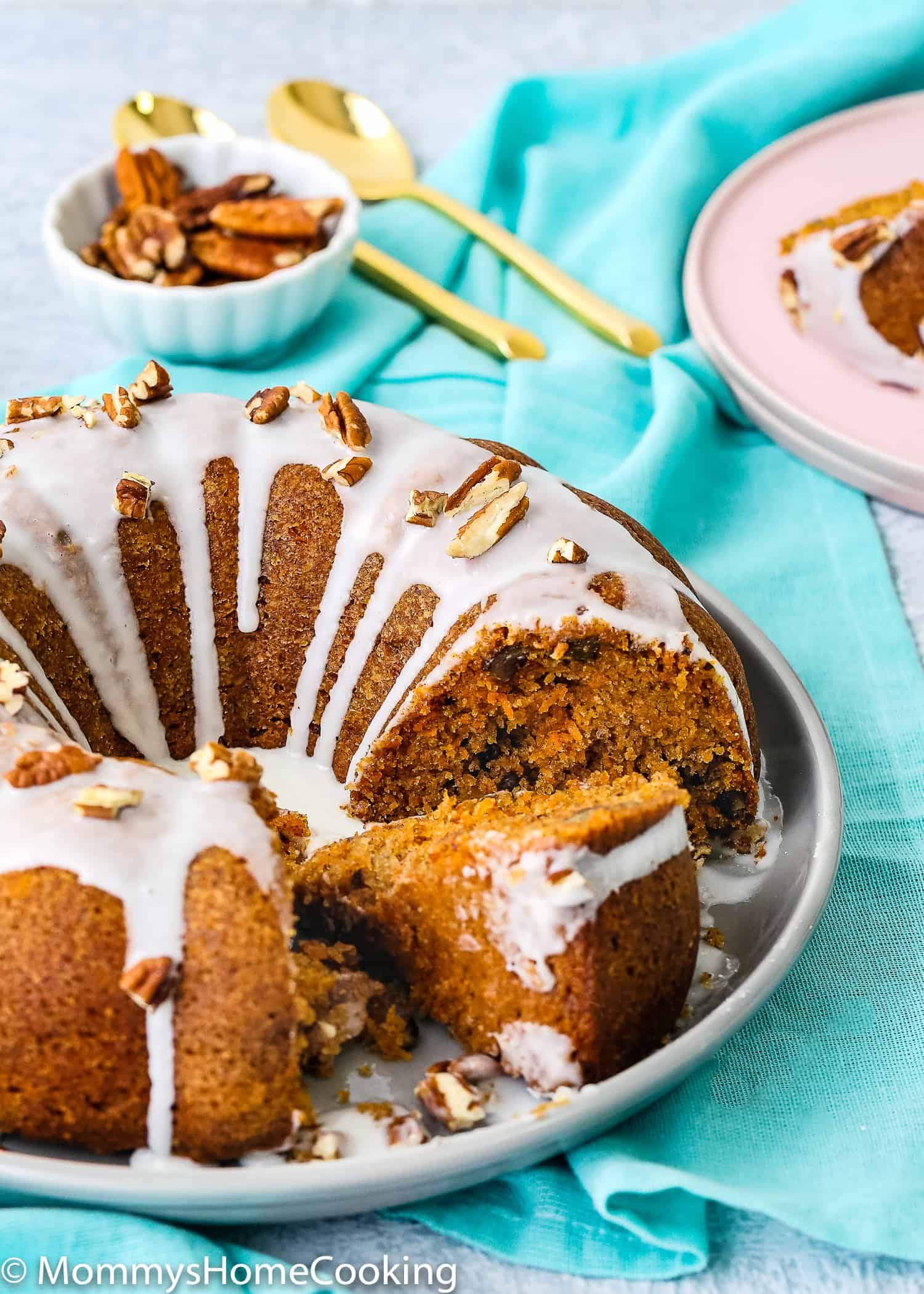 sliced eggless carrot cake on a plate over a blue kitchen napkin 