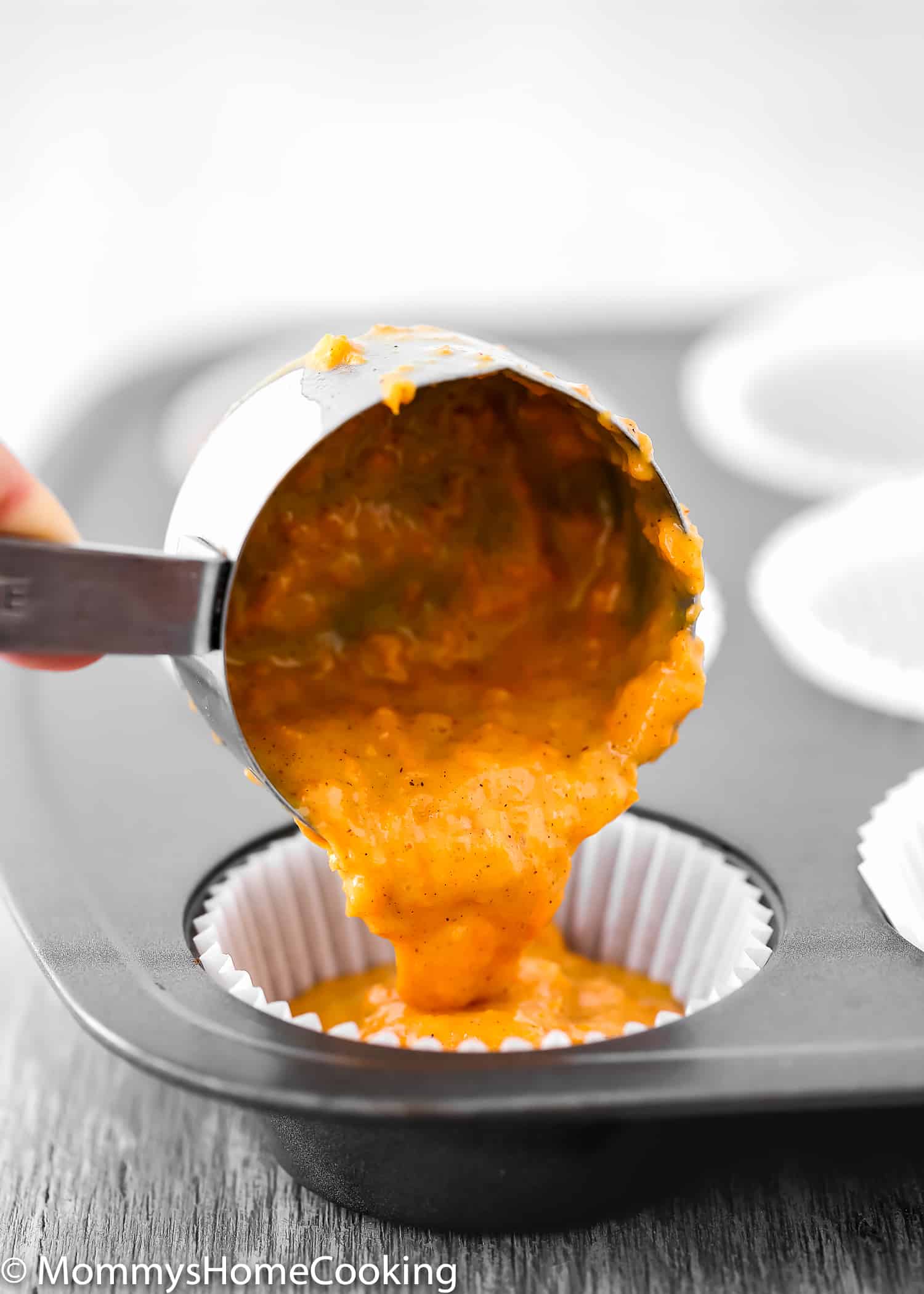 Eggless Carrot Cake Cupcakes batter being pour into a cupcake paper cup. 