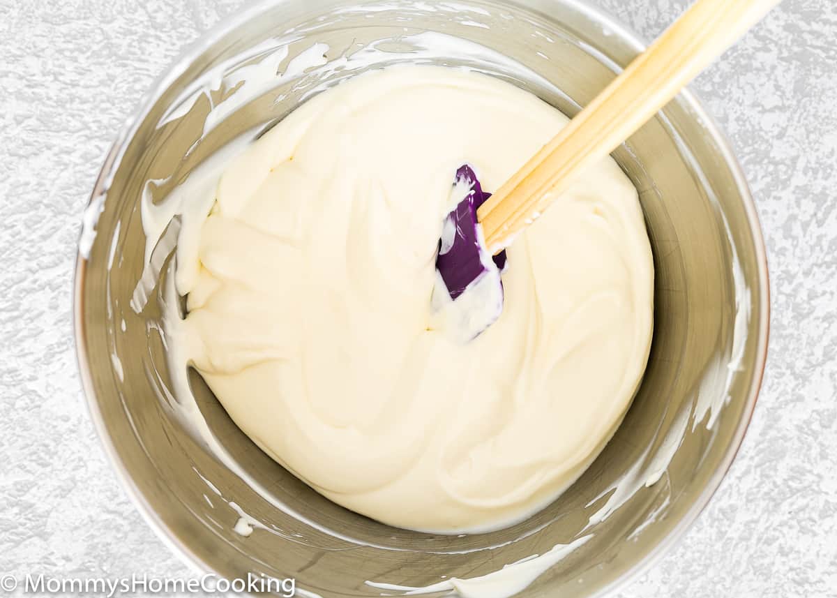 Eggless Cheesecake Batter in a metal bowl with a spatula.