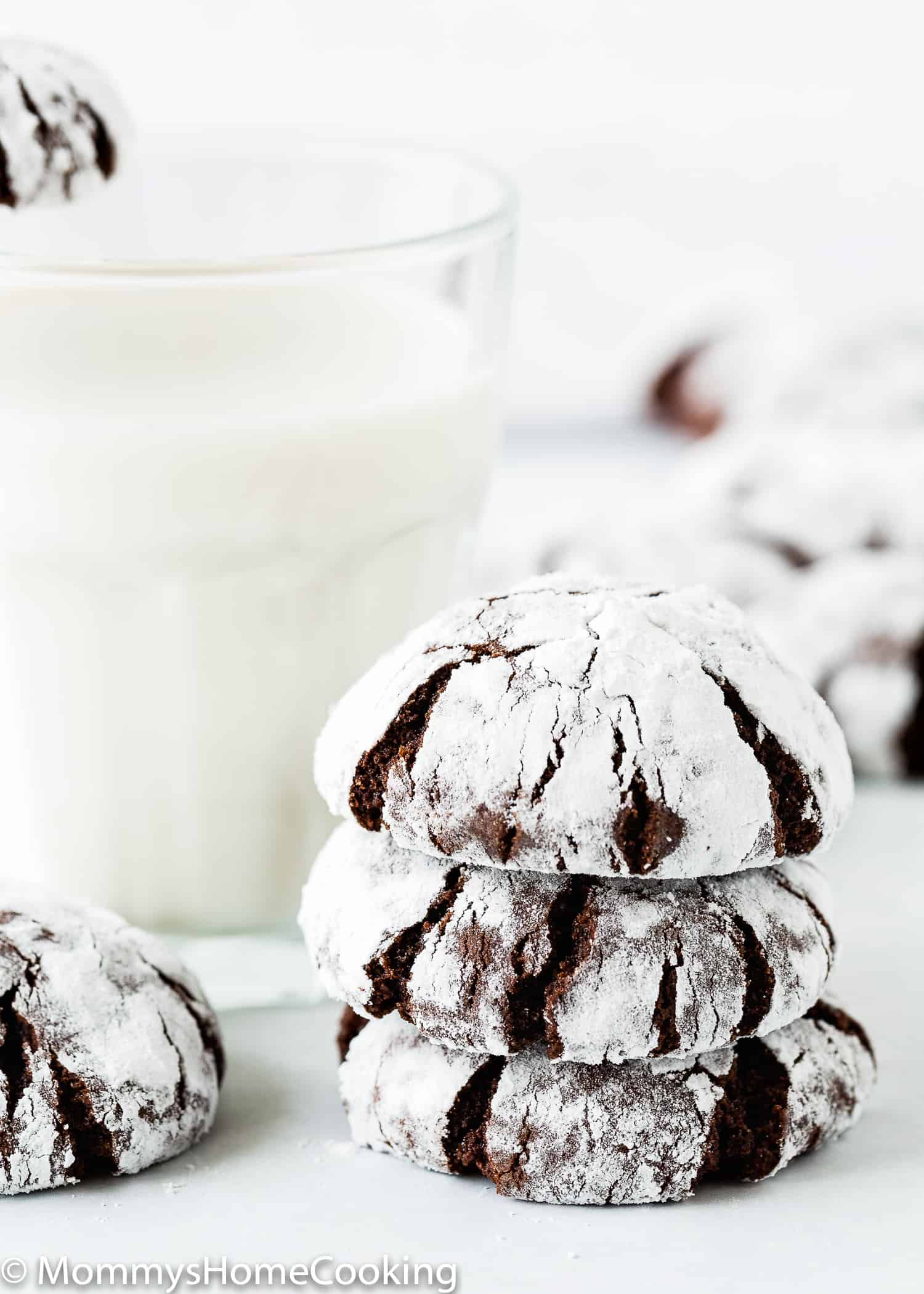 stack of three Eggless Chocolate Crinkle Cookies with a glass of milk