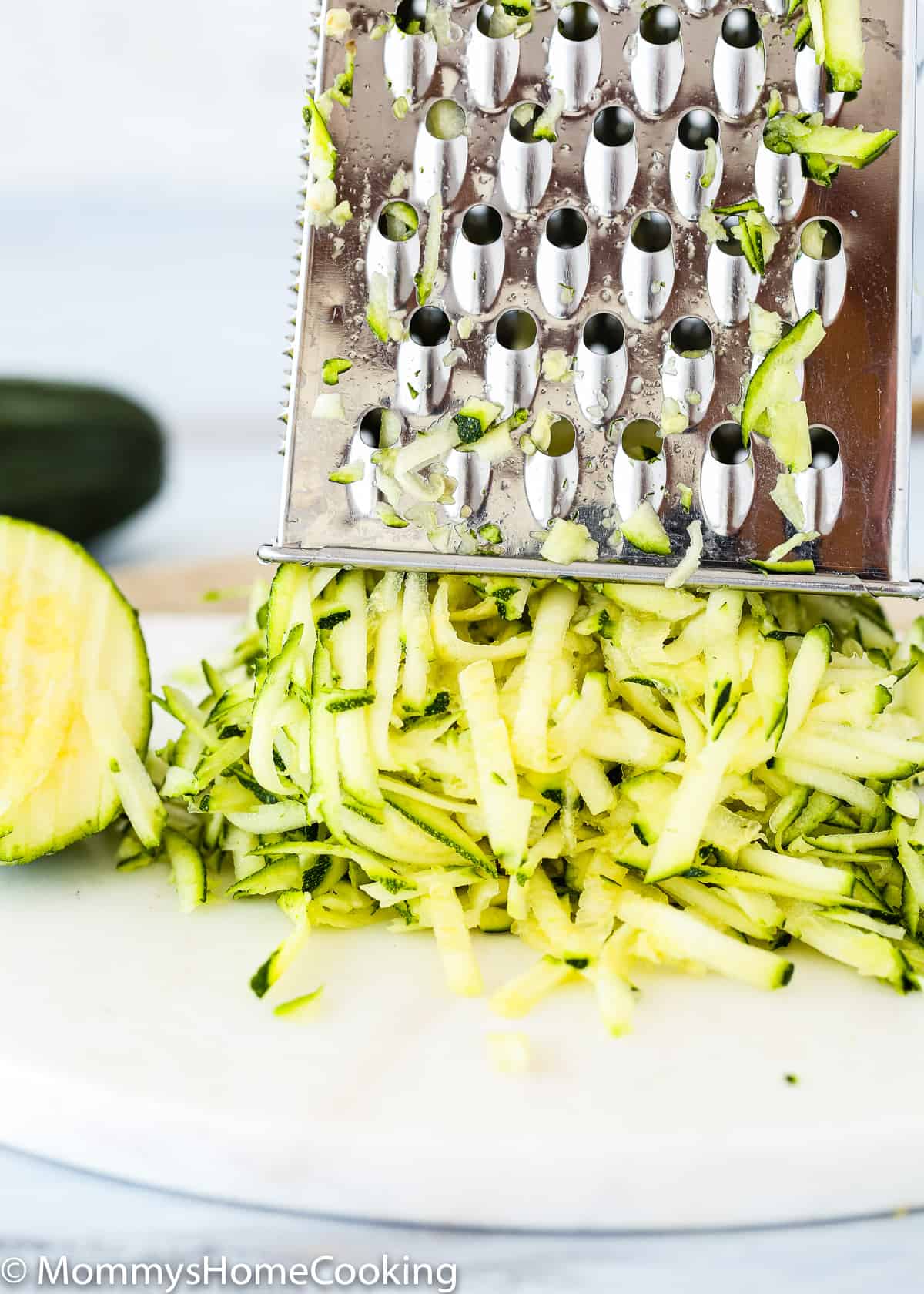 Shredded zucchini over a cutting board