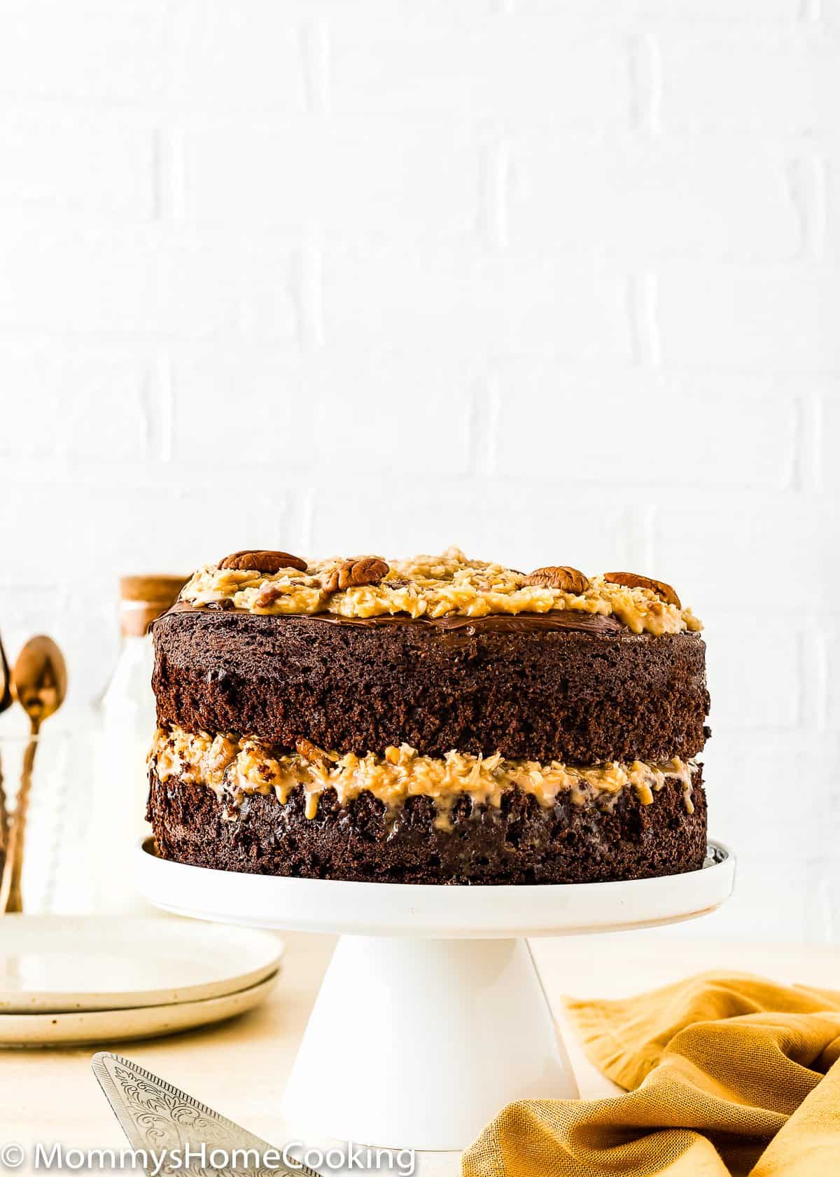 Eggless German Chocolate Cake on a cake stand.