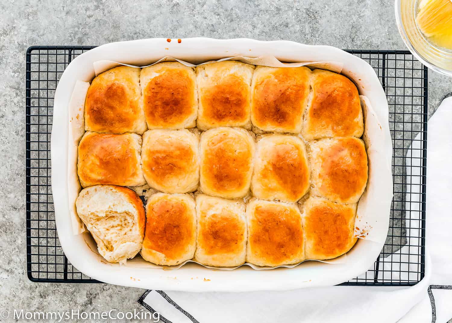 egg-free homemade hawaiian rolls in a baking dish over a gray surface.