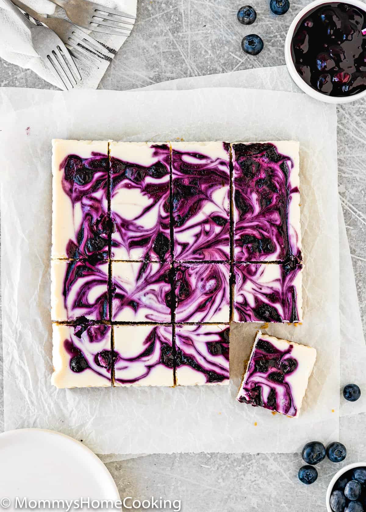 over head view of Eggless Lemon Blueberry Cheesecake Bars cut into squares