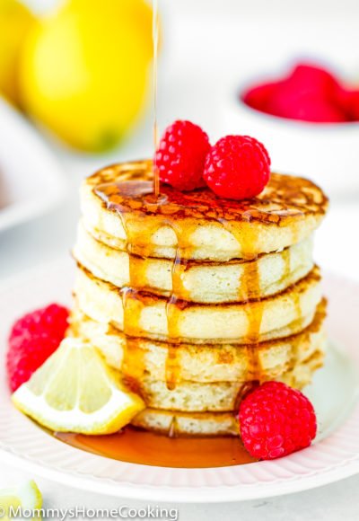 maple syrup poured over a stack of eggless lemon Ricotta pancakes