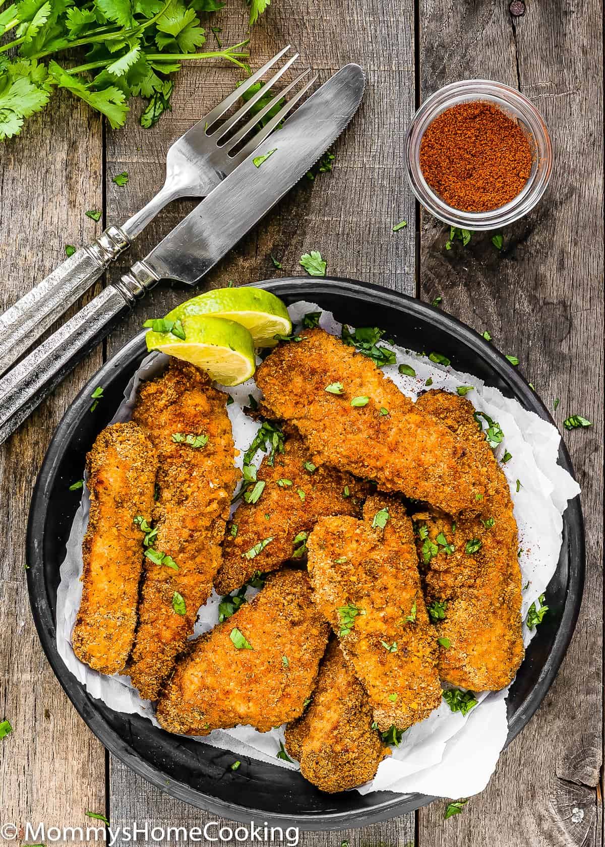 Eggless Oven Fried Chicken Tenders garnished with lemon wedges.