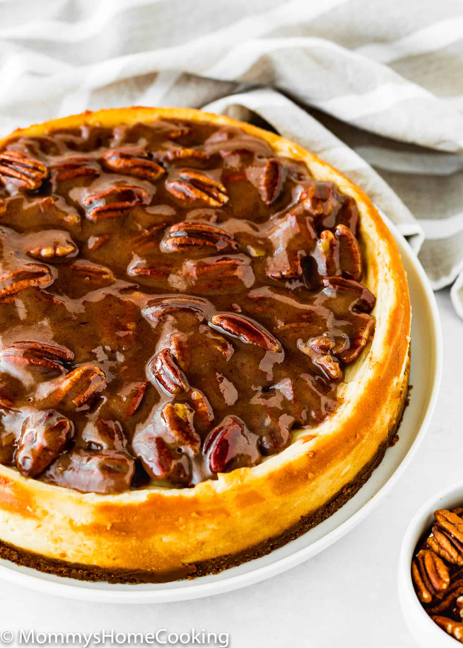 whole Eggless Pecan Pie Cheesecake on a serving plate.