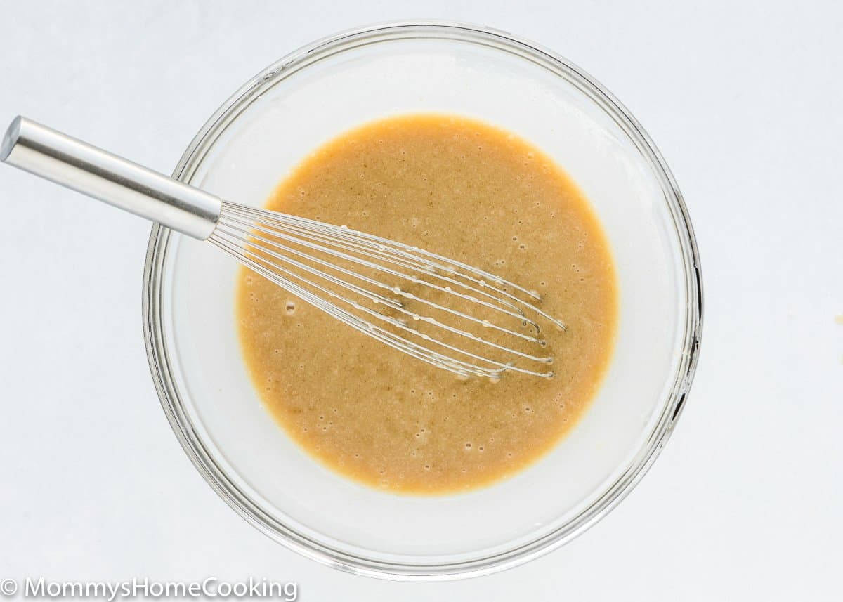 wet ingredients to make egg-free cake in a bowl with a whisk.