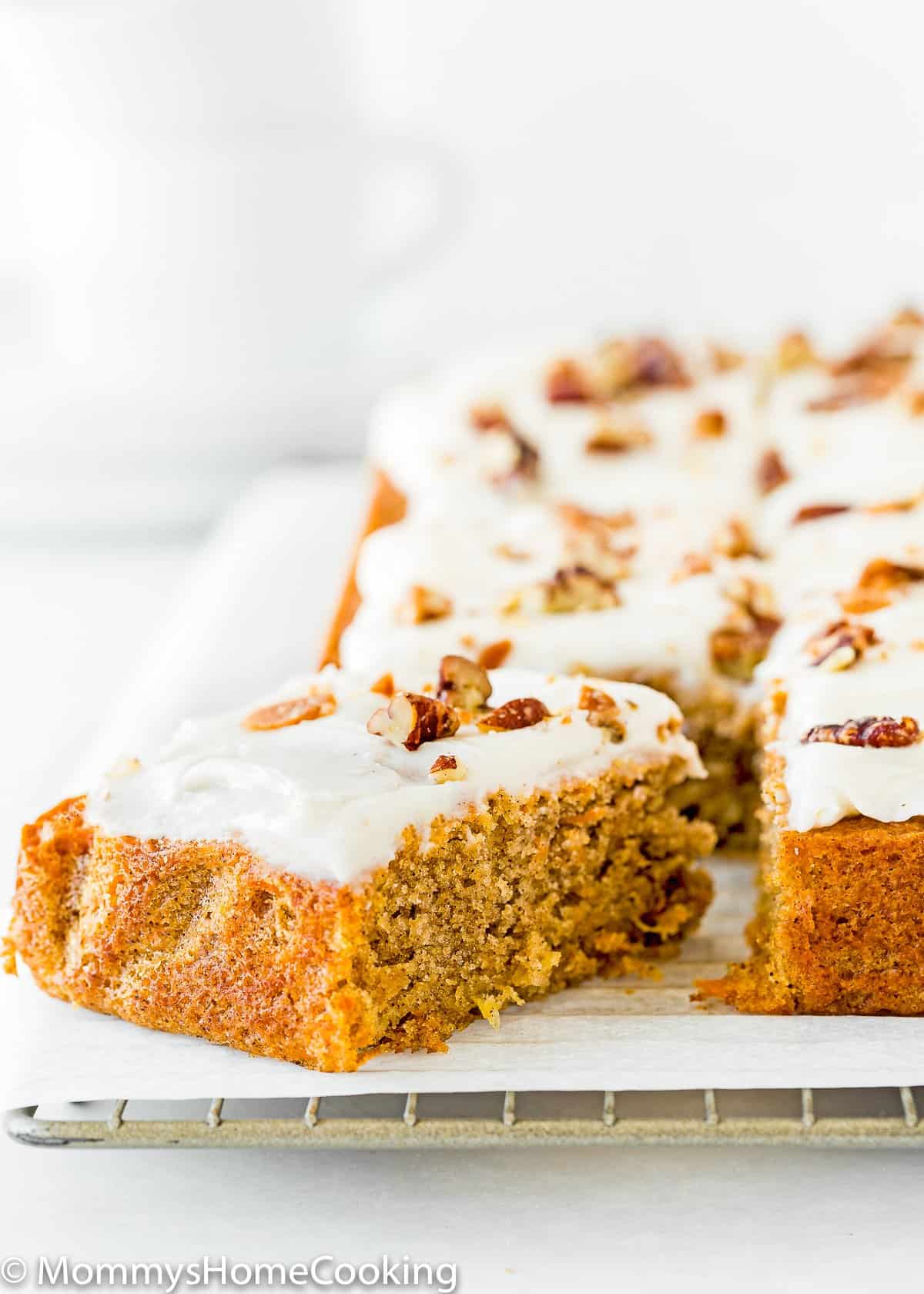 cut Eggless Pineapple Carrot Sheet Cake over a cooling rack.