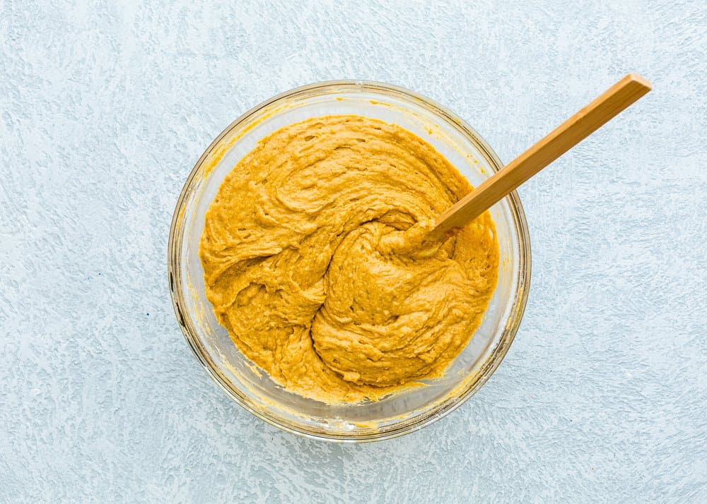 eggless pumpkin cake batter in a bowl with a spatula.