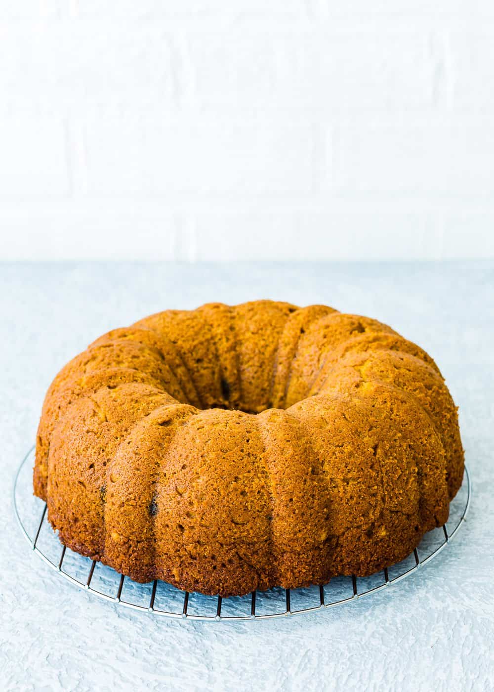 baked eggless pumpkin cake over a cooling rack. 