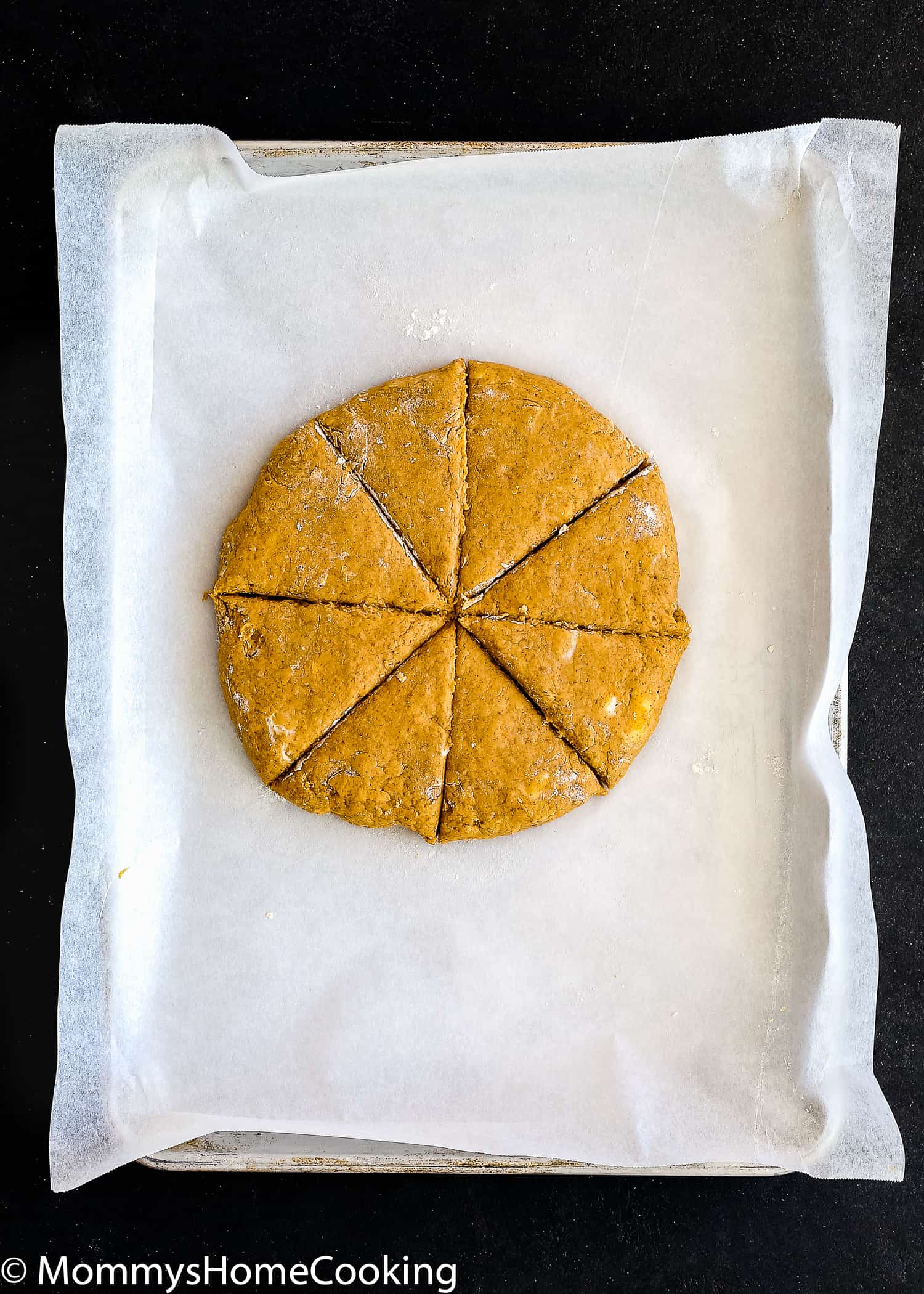 Overhead view of pumpkin scone dough in the sheet pan after cutting.