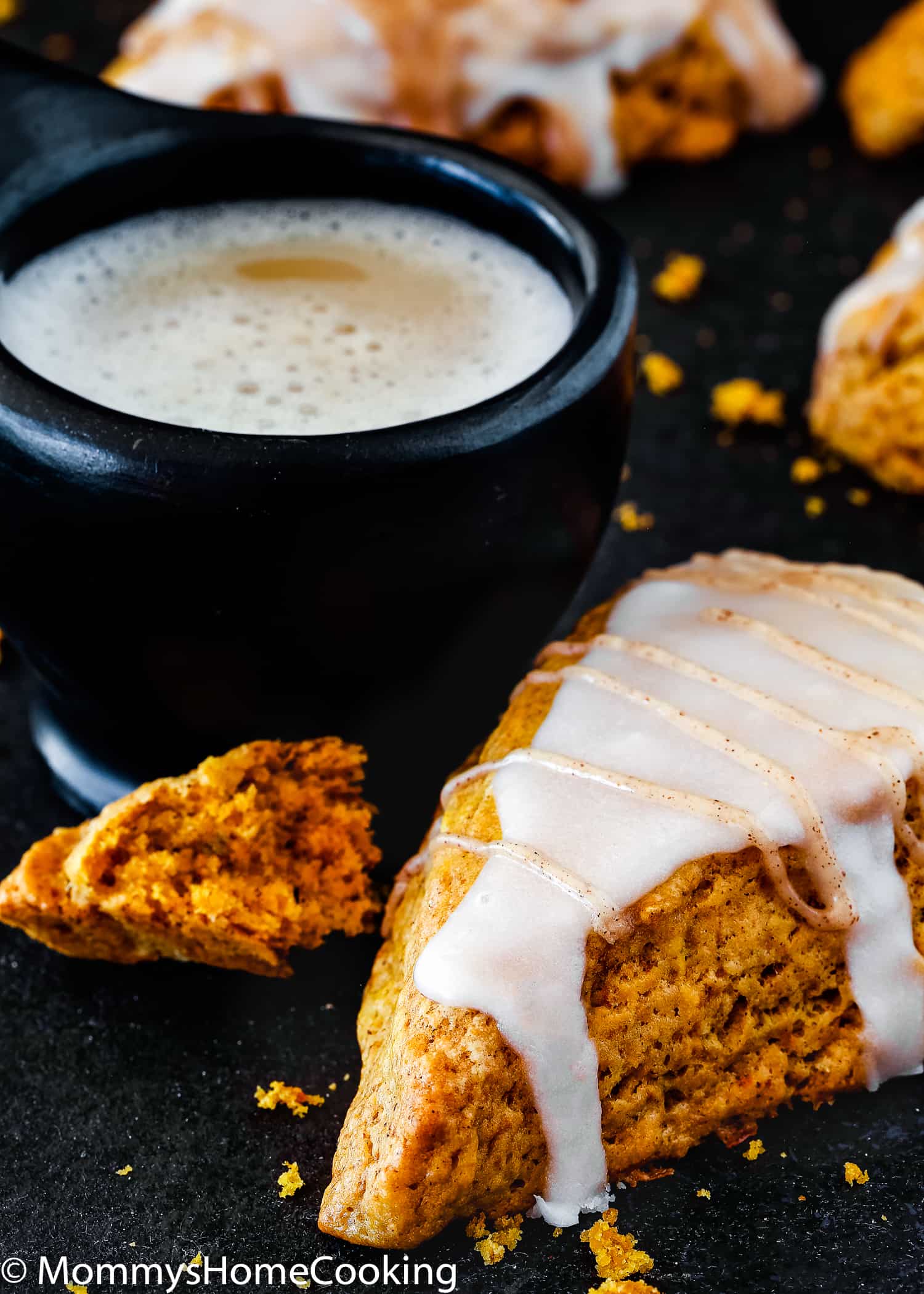 A egg-free pumpkin scone next to a cup of chai. 