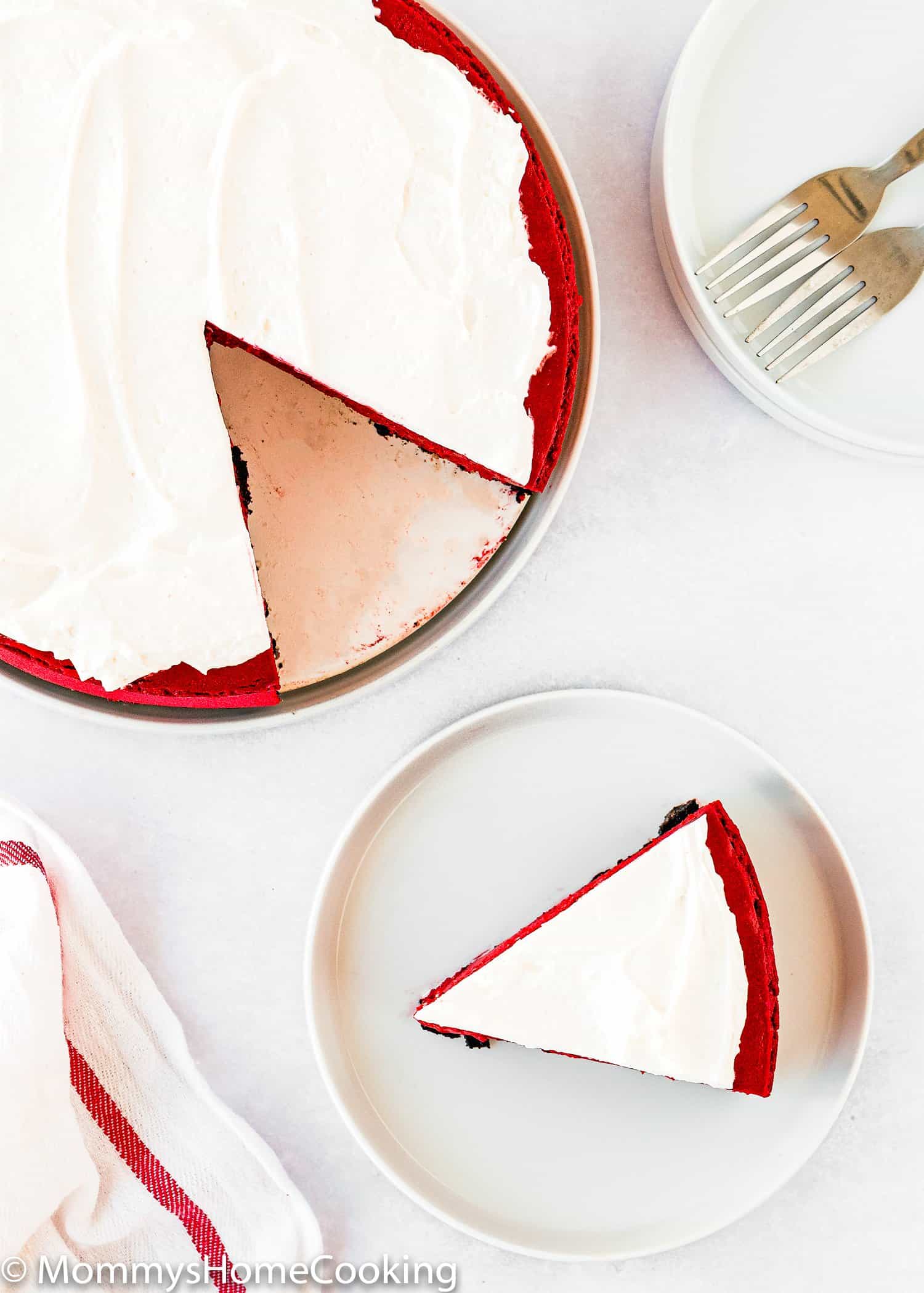 cut Eggless Red Velvet Cheesecake over a white surface